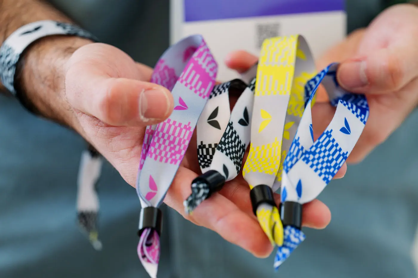 Hands holding Future Human wristbands