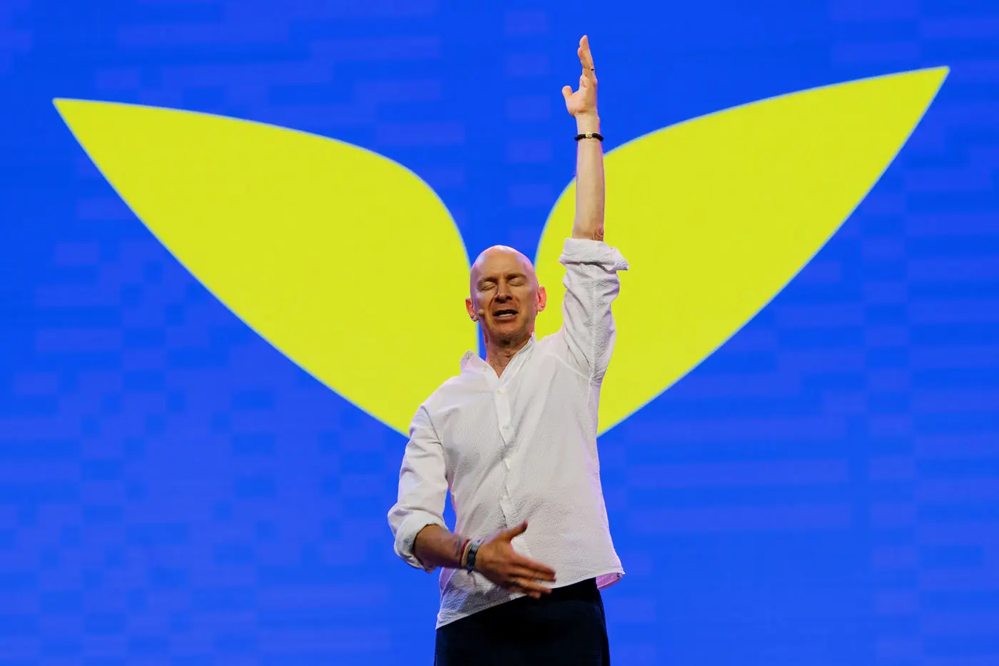 Speaker on stage with arms raised