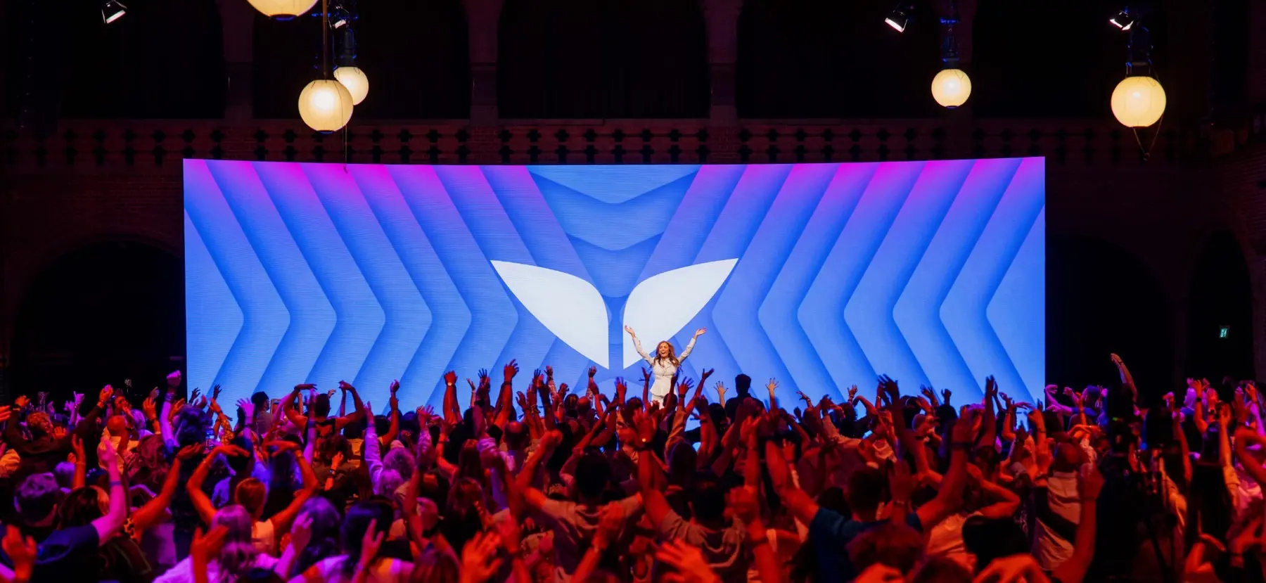 Crowd with hands raised in front of the Mindvalley U main stage