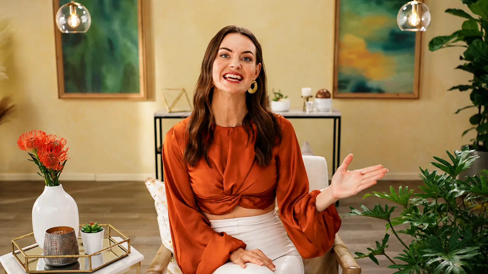 Speaker in an orange blouse on a sand-toned set